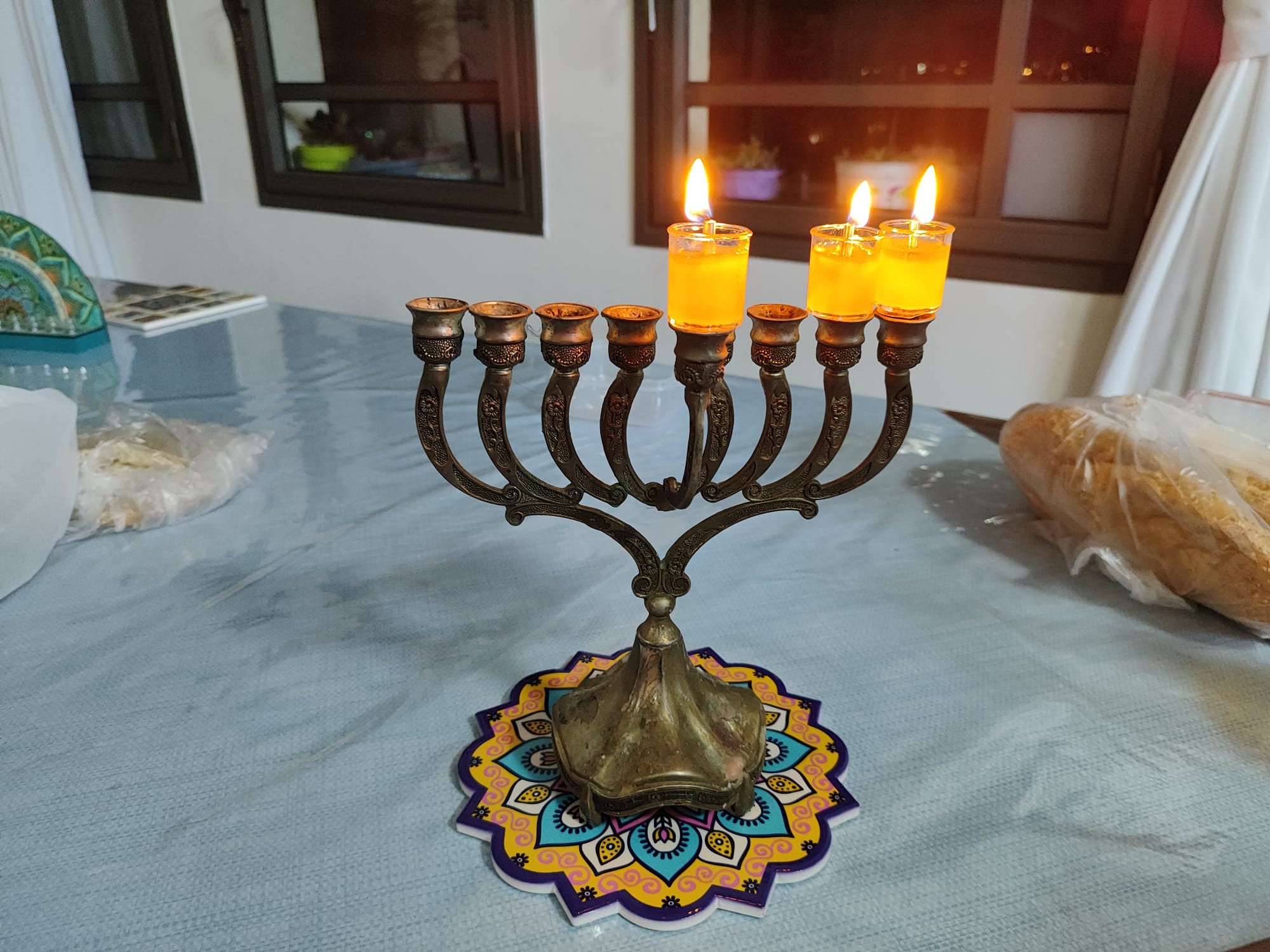 חנוכיית פליז עם נרות שמן דולקים בערב החג