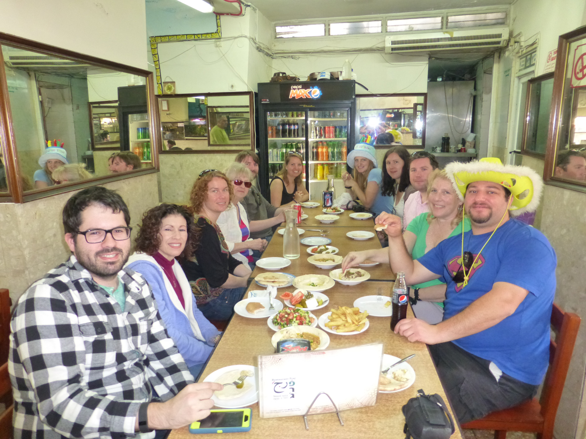 קבוצת מטיילים סביב שולחן ארוך עם טעימות כשרות במסעדה בעיר התחתית של חיפה