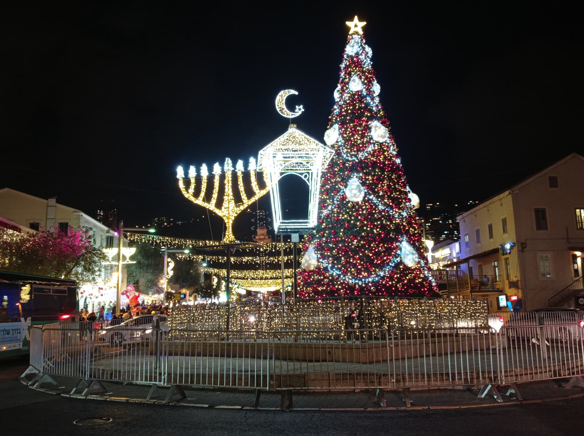 חנוכייה, סהר ועץ אשוח מוארים בלילה במושבה הגרמנית